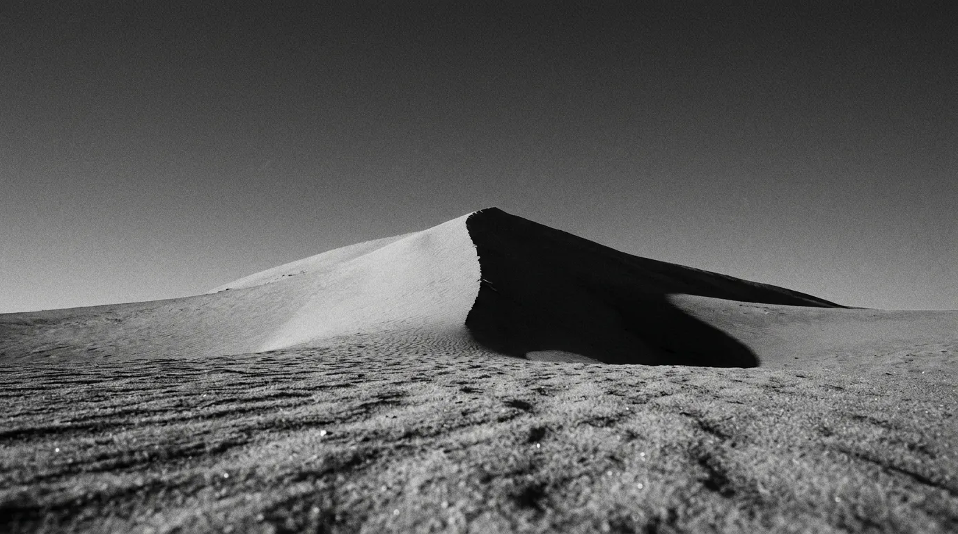 Crête de dune rouge à Tel Moreeb au lever du soleil, ligne d'ombre nette qui partage la dune en deux, aucune trace humaine, grain de sable en premier plan net, ciel cobalt en arrière-plan